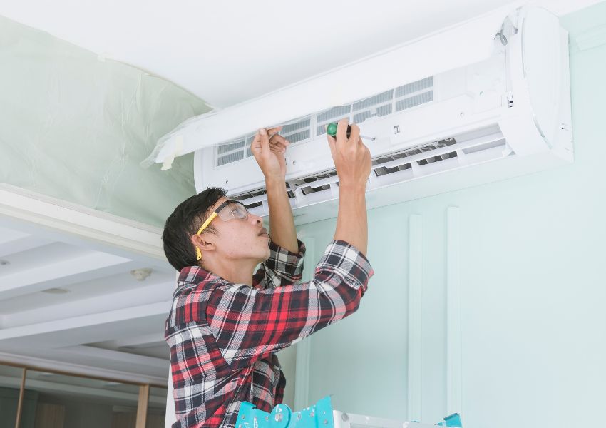 home%20inspector%20using%20a%20tool%20to%20fix%20part%20of%20an%20air%20conditioning%20unit